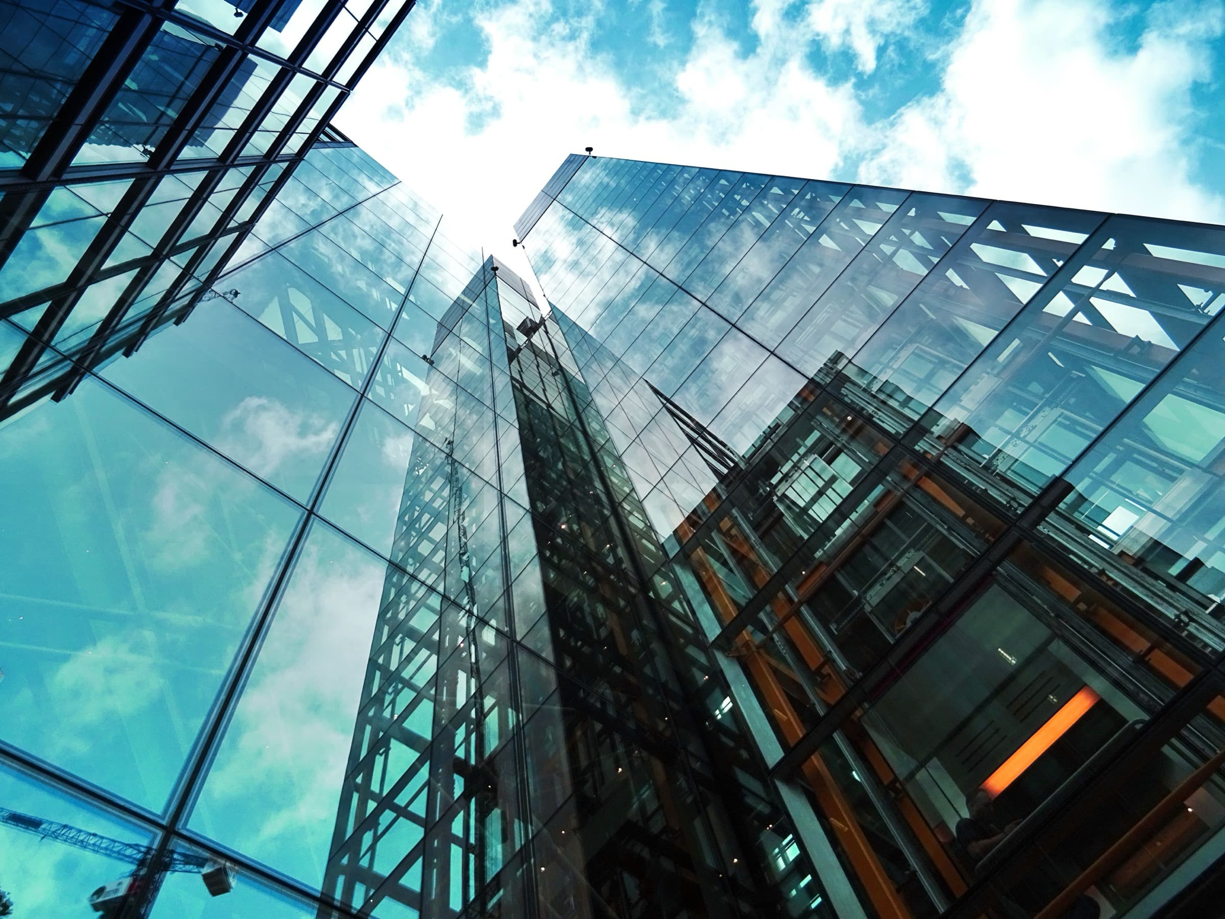 Glass office towers seen from street level against the sky