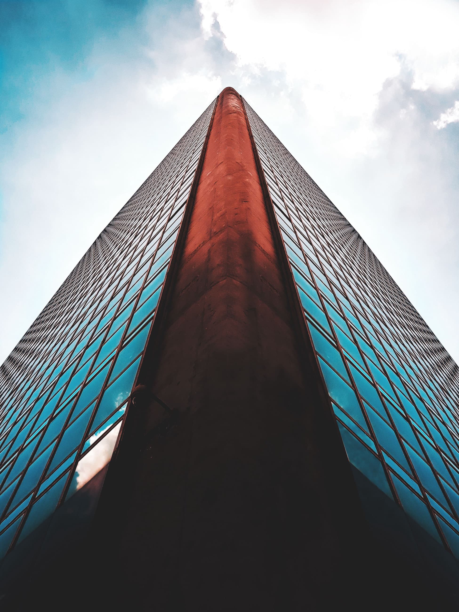 Glass office towers seen from below, converging against the sky