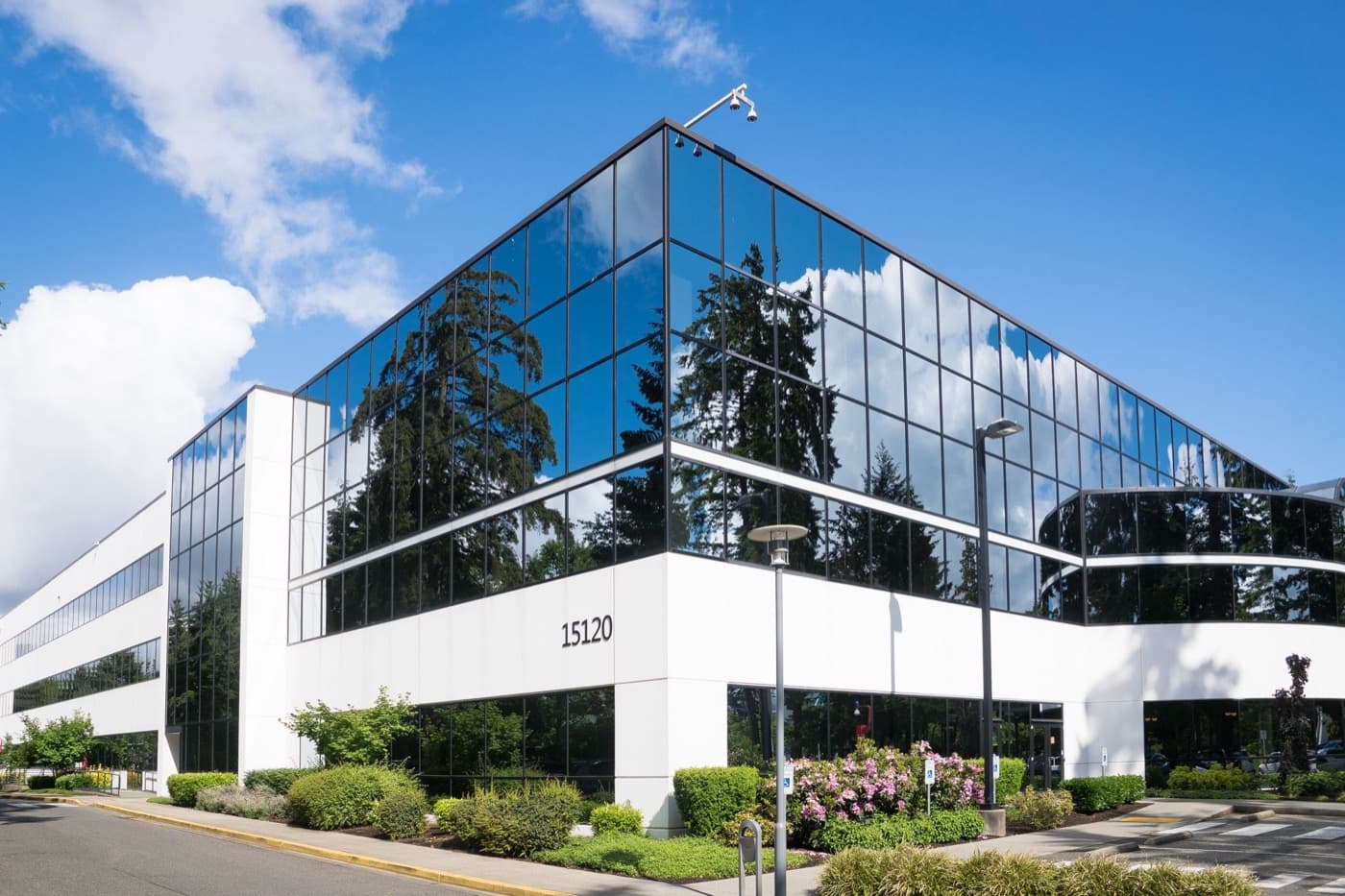 A glass office building under a blue sky