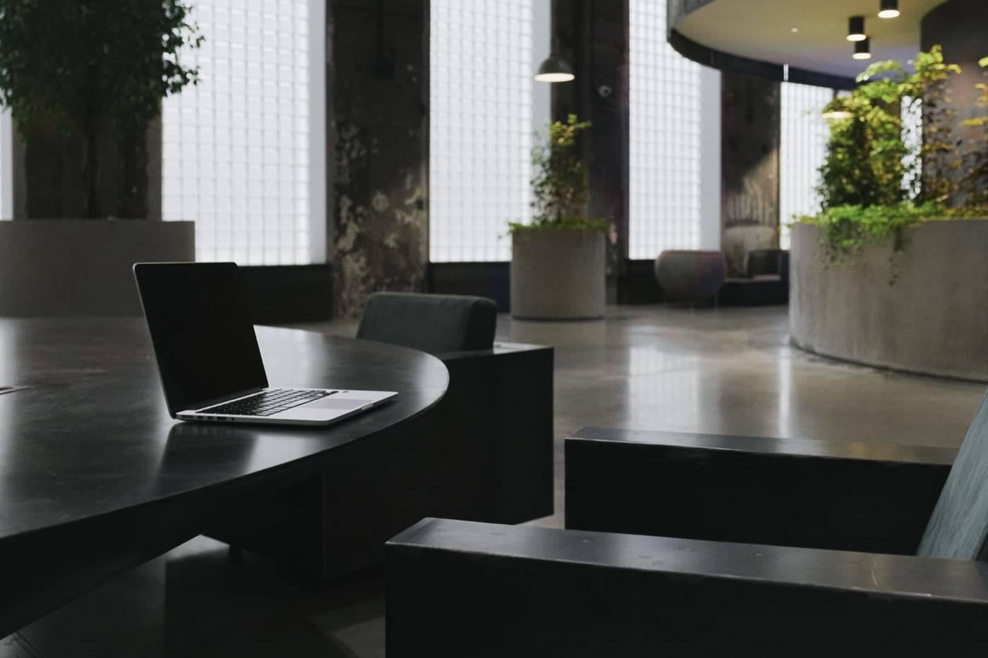 A modern meeting space with a long table, set for a session