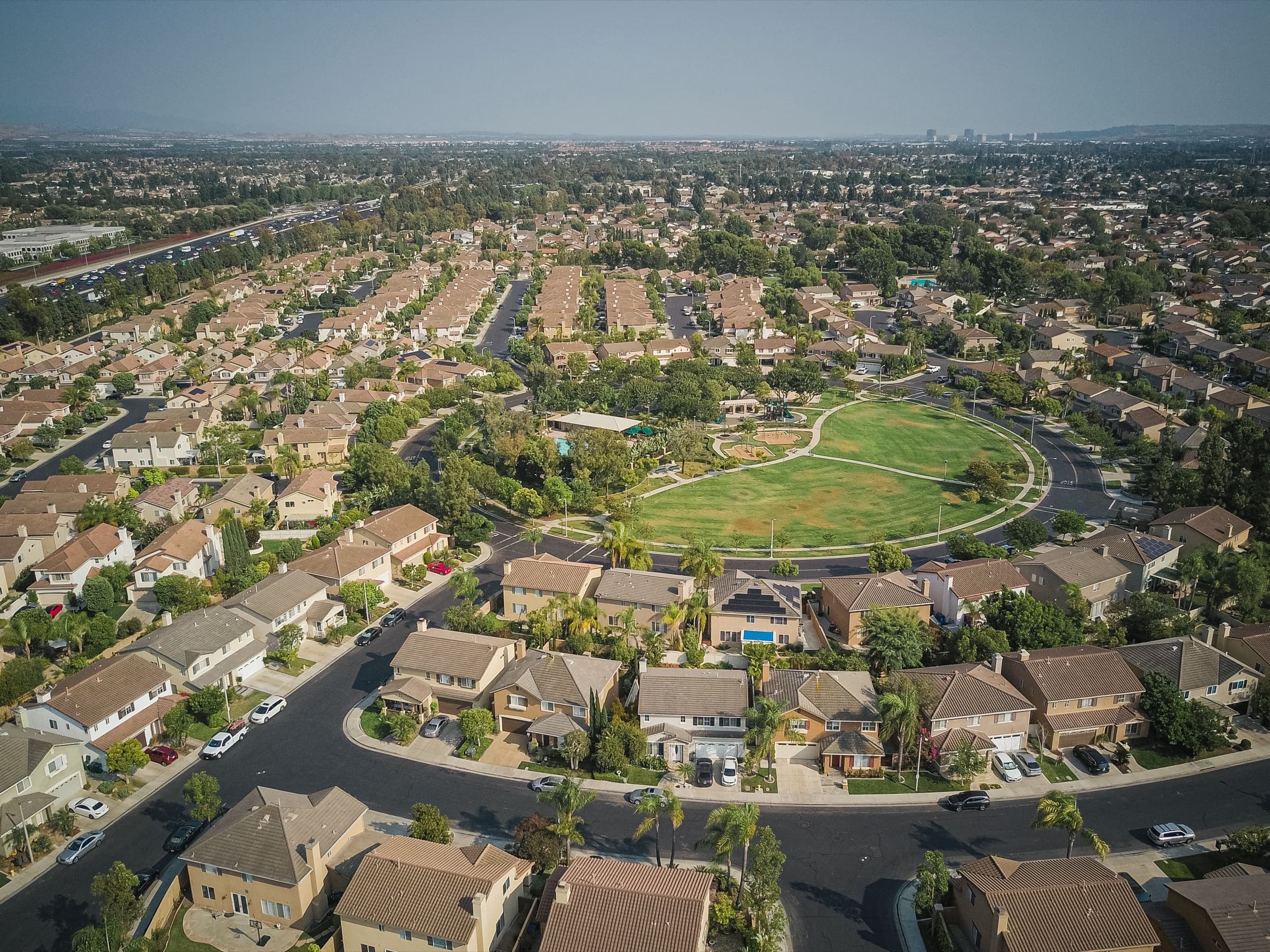 Aerial view of a suburban neighborhood with a green park at its center